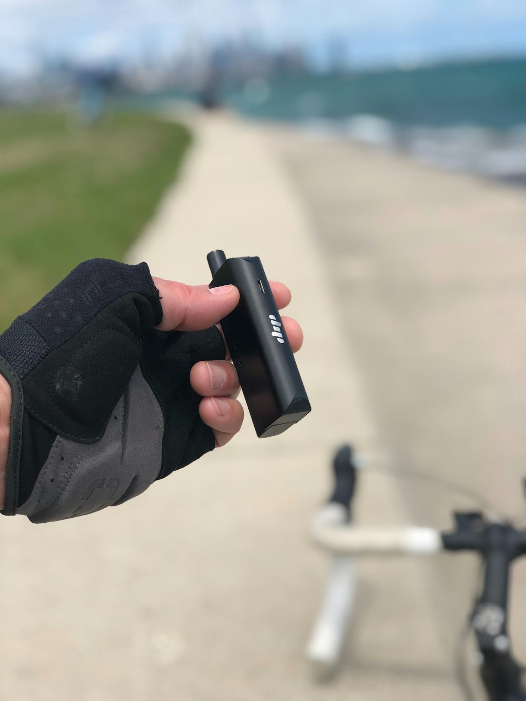 A bicyclist holds a Dip Devices EVRI 3-in-1 multifunction vape pen and electric dab straw. Get yours at https://dipdevices.com/